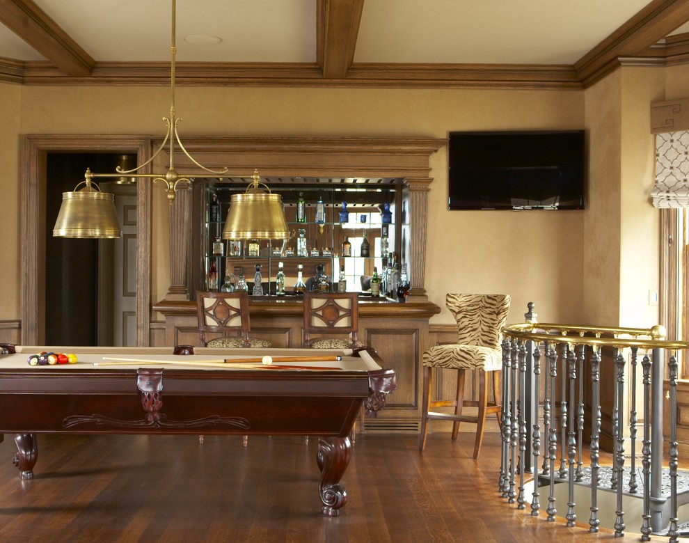 This is an example of a large traditional open plan games room in New York with beige walls, medium hardwood flooring, no fireplace, a wall mounted tv, brown floors and a dado rail.