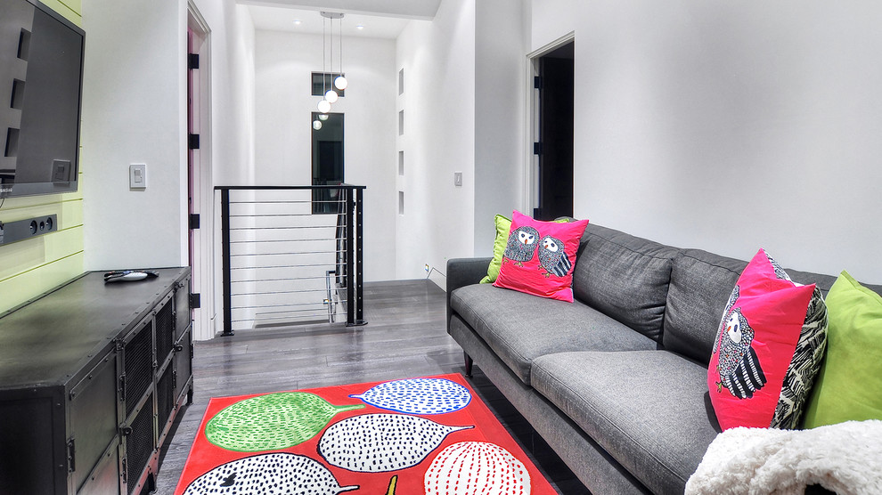 Esempio di un soggiorno minimalista di medie dimensioni e stile loft con pareti bianche, pavimento in bambù, TV a parete e pavimento marrone