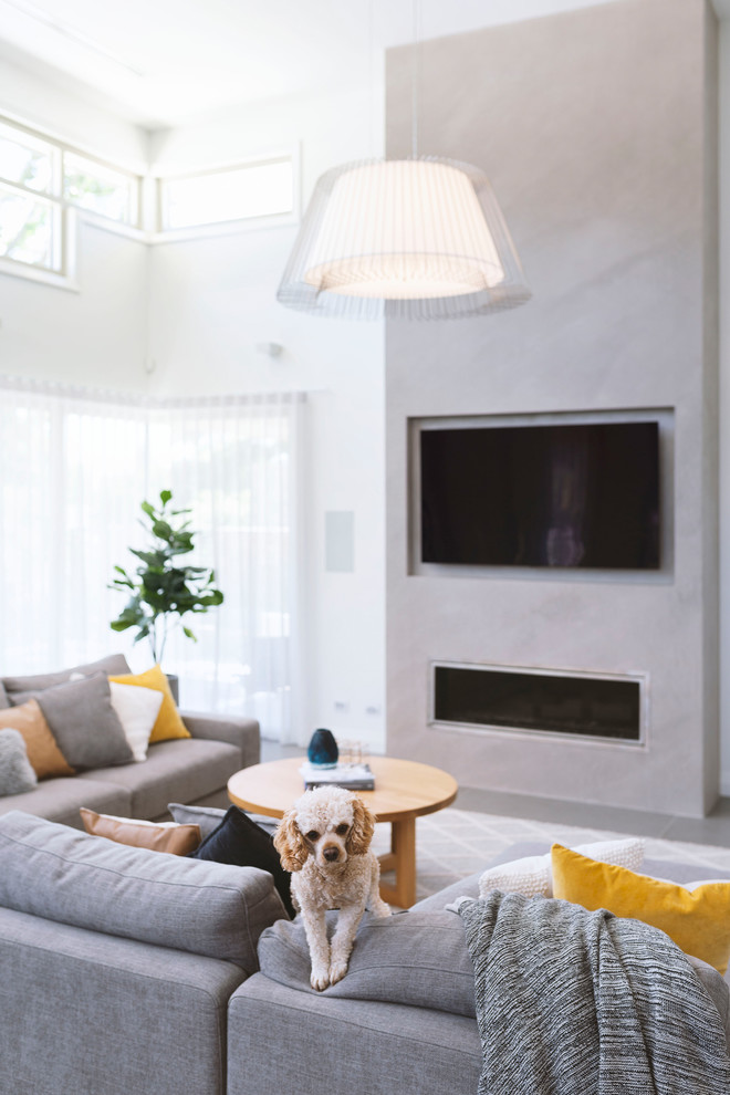 Foto de sala de estar actual con paredes blancas, estufa de leña, marco de chimenea de yeso, televisor colgado en la pared y suelo naranja