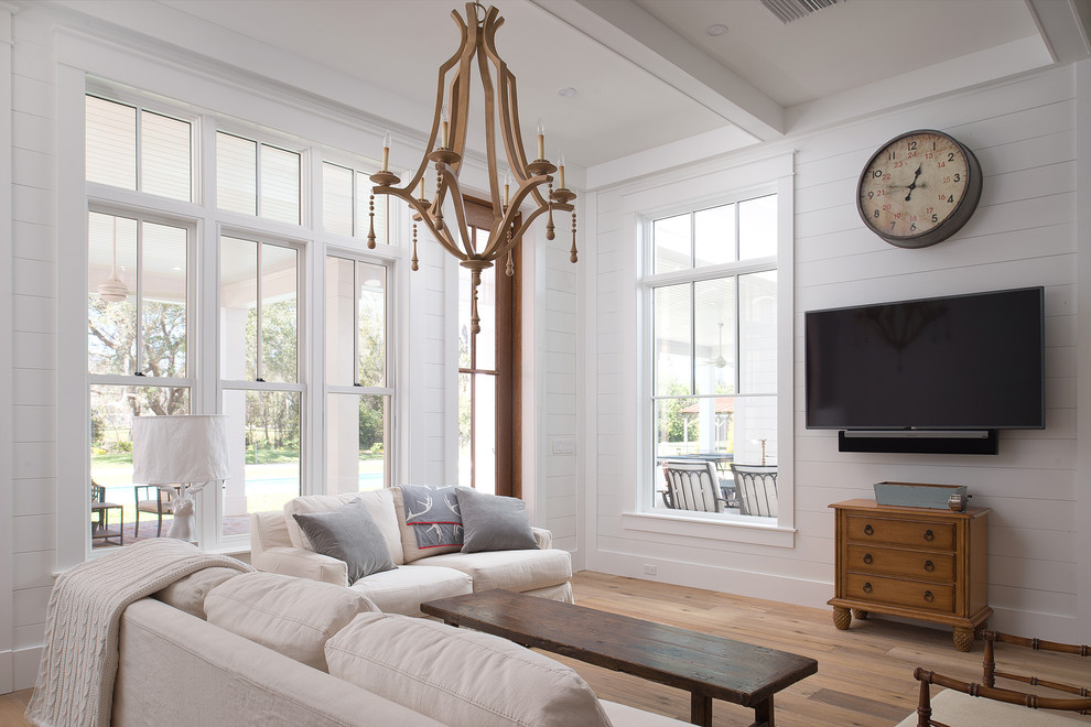 Foto de sala de estar abierta clásica renovada grande con paredes blancas, suelo de madera en tonos medios y televisor colgado en la pared