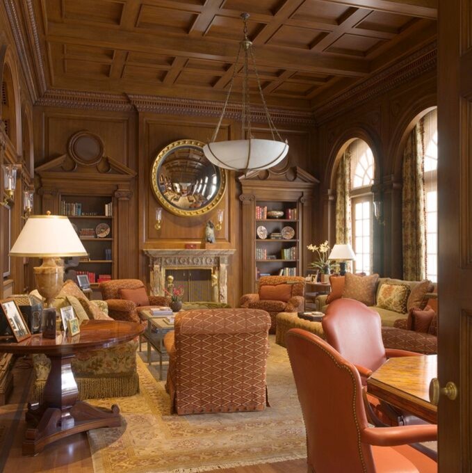 Réalisation d'une très grande salle de séjour tradition fermée avec une bibliothèque ou un coin lecture, un mur marron, parquet clair, une cheminée standard, un manteau de cheminée en pierre et un sol marron.