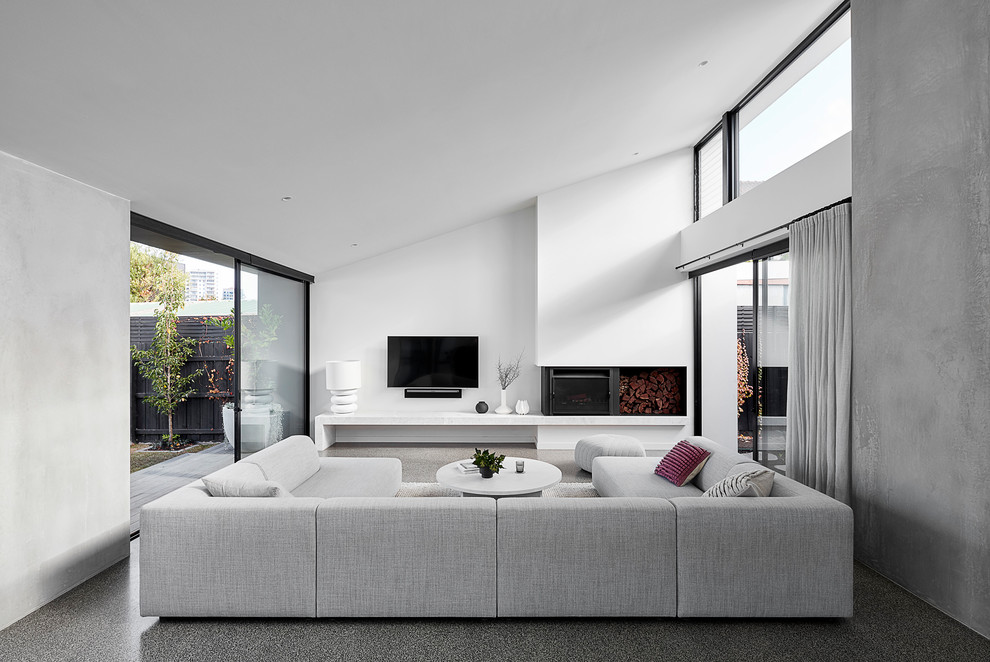 Свежая идея для дизайна: большая открытая гостиная комната в современном стиле с белыми стенами, бетонным полом, телевизором на стене, серым полом и печью-буржуйкой - отличное фото интерьера
