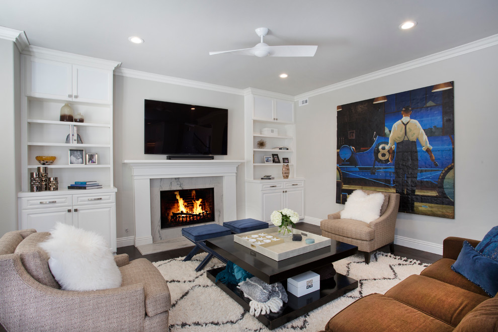 Foto de sala de estar tradicional renovada de tamaño medio con paredes grises, suelo de madera oscura, todas las chimeneas, marco de chimenea de piedra y televisor independiente