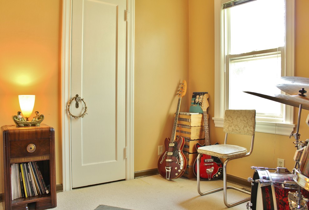 Cette image montre une salle de séjour bohème fermée avec une salle de musique et un mur jaune.