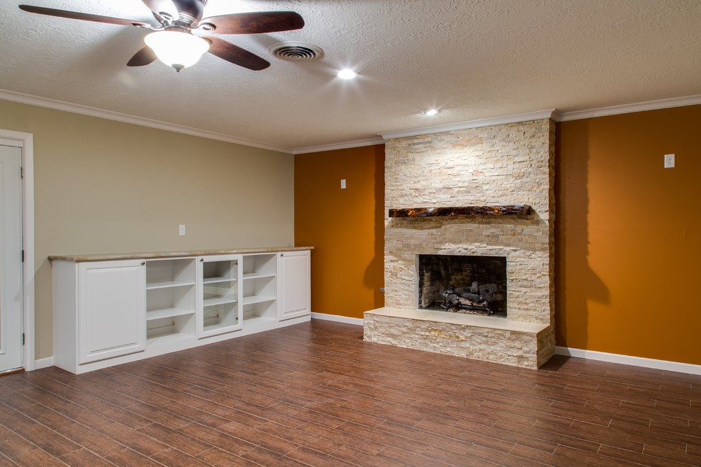 Large elegant open concept porcelain tile and brown floor family room library photo in Houston with orange walls, a standard fireplace, a stone fireplace and a media wall