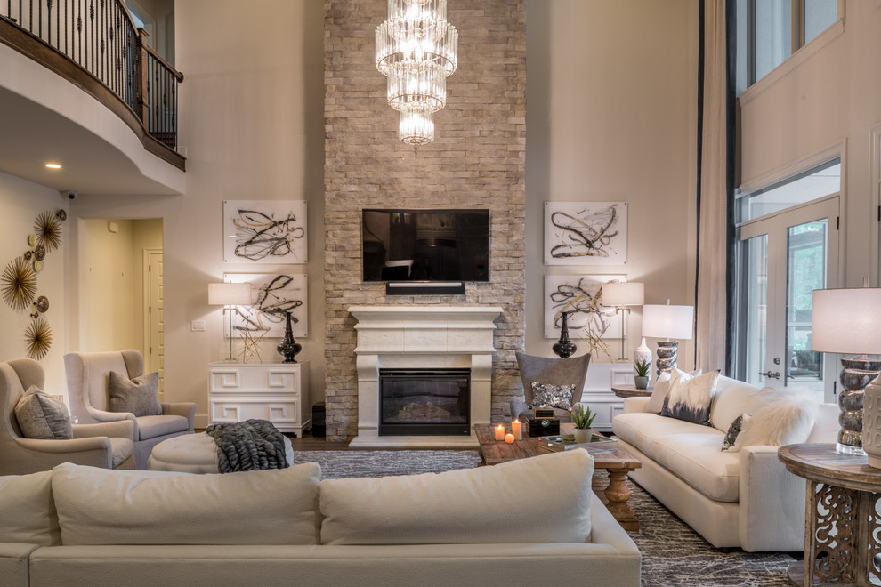 Foto de sala de estar abierta tradicional renovada grande con paredes blancas, suelo de madera en tonos medios, todas las chimeneas, marco de chimenea de hormigón, televisor colgado en la pared y suelo marrón