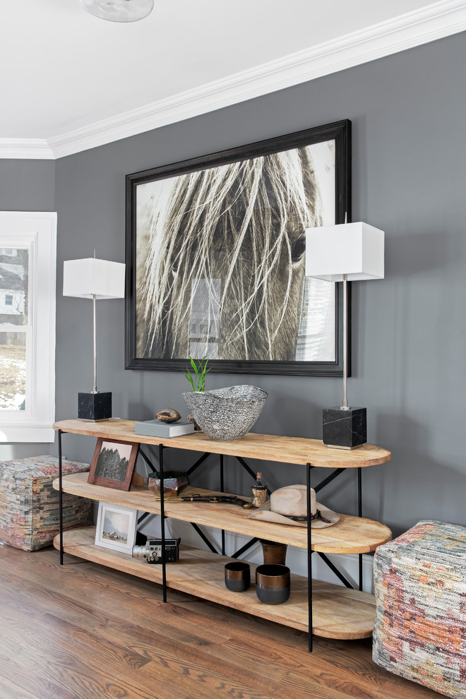 Esempio di un soggiorno minimalista di medie dimensioni e chiuso con pareti grigie, parquet chiaro, nessun camino, TV a parete e pavimento marrone