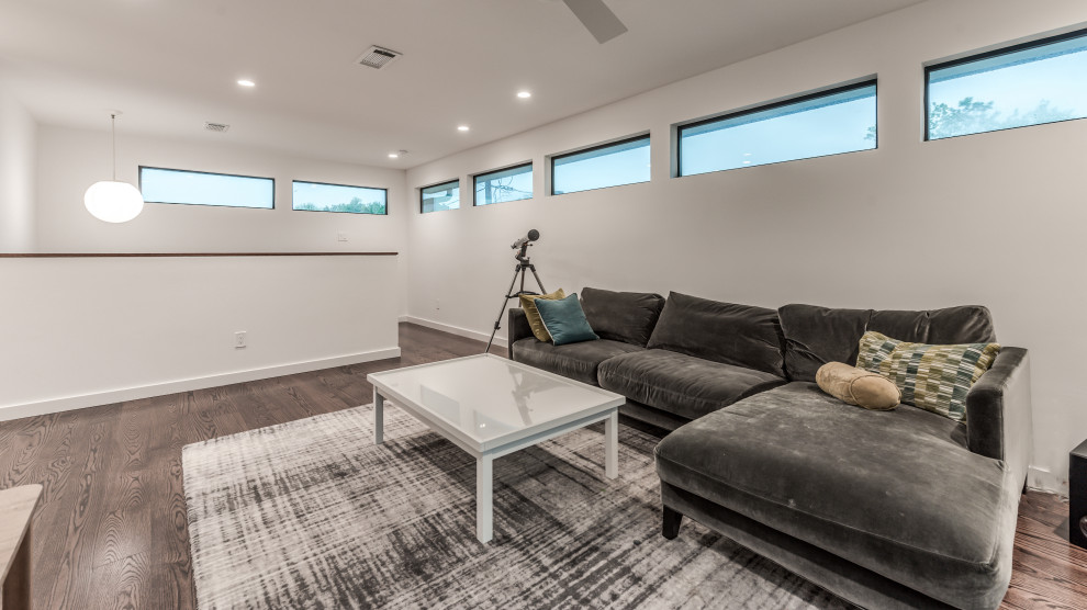 Esempio di un soggiorno design di medie dimensioni e aperto con pareti bianche, pavimento in legno massello medio, TV a parete e pavimento marrone