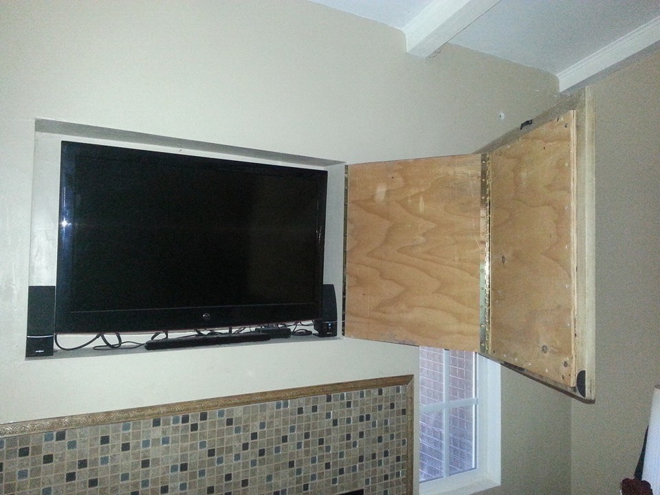 Immagine di un piccolo soggiorno design chiuso con pareti beige e TV nascosta