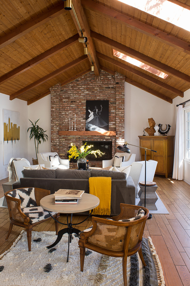 Mid-sized transitional open concept light wood floor and brown floor family room photo in Los Angeles with white walls, a standard fireplace, a brick fireplace and a concealed tv