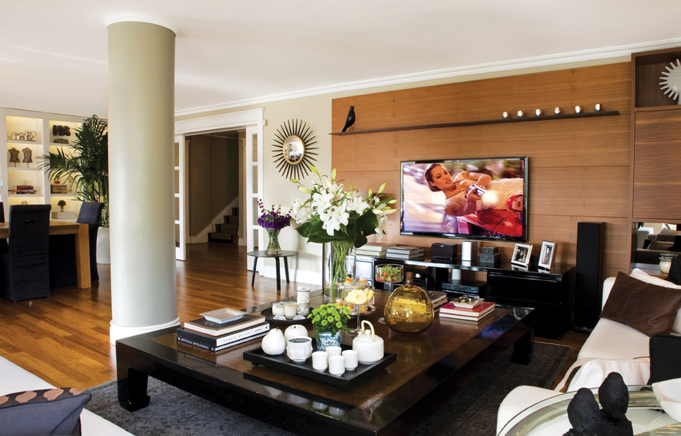 Idée de décoration pour une salle de séjour design ouverte avec un mur beige, un sol en bois brun et un téléviseur fixé au mur.