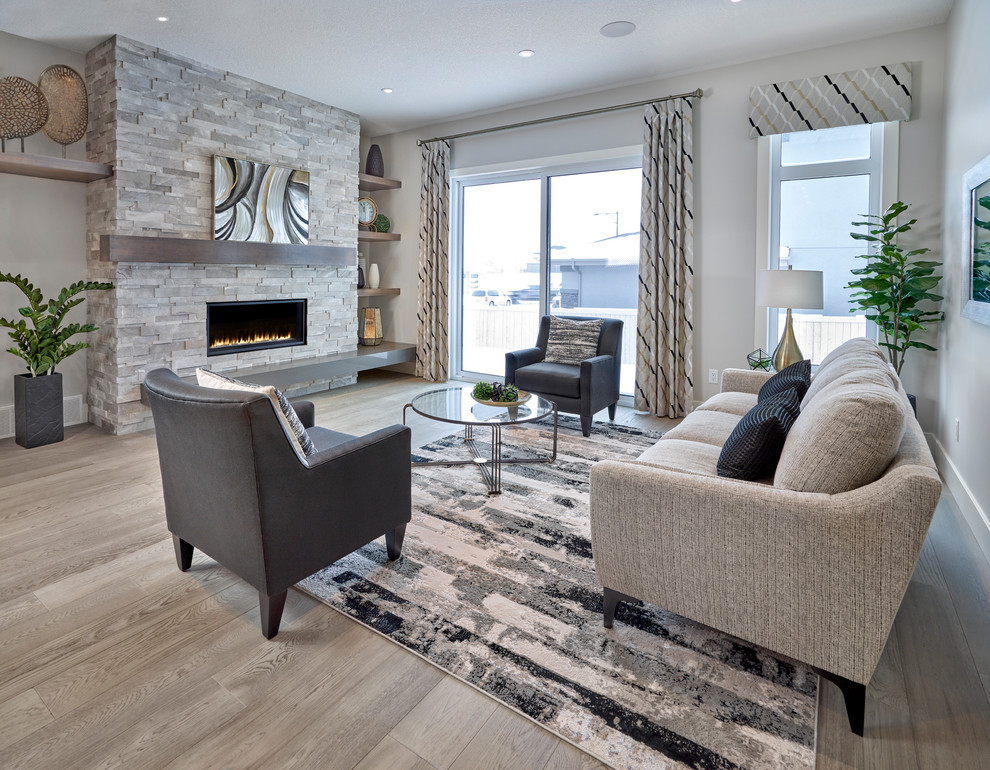Mittelgroßes, Fernseherloses, Offenes Klassisches Wohnzimmer mit grauer Wandfarbe, braunem Holzboden, Kamin, Kaminumrandung aus Stein und grauem Boden in Edmonton