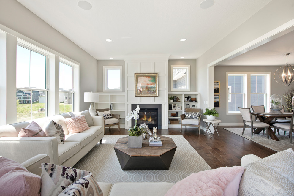 Foto de sala de estar abierta tradicional renovada grande con paredes grises, suelo de madera en tonos medios, todas las chimeneas y marco de chimenea de piedra