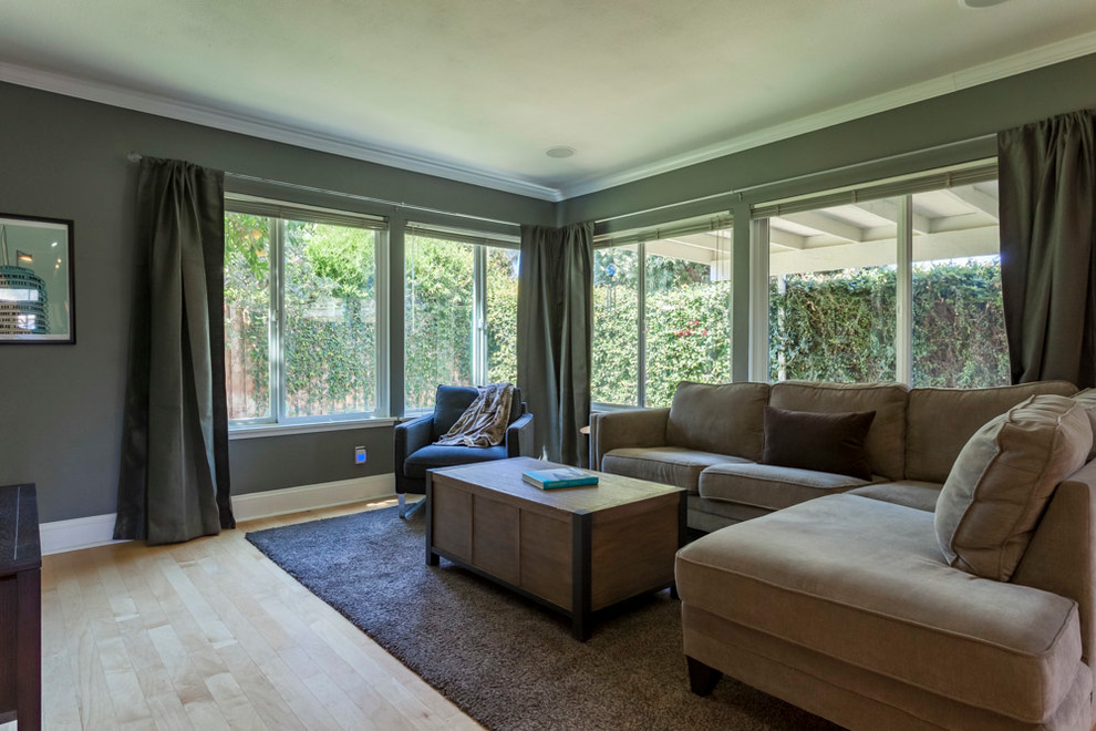 Idée de décoration pour une salle de séjour design de taille moyenne et ouverte avec un mur gris, parquet clair, un téléviseur indépendant et un sol marron.