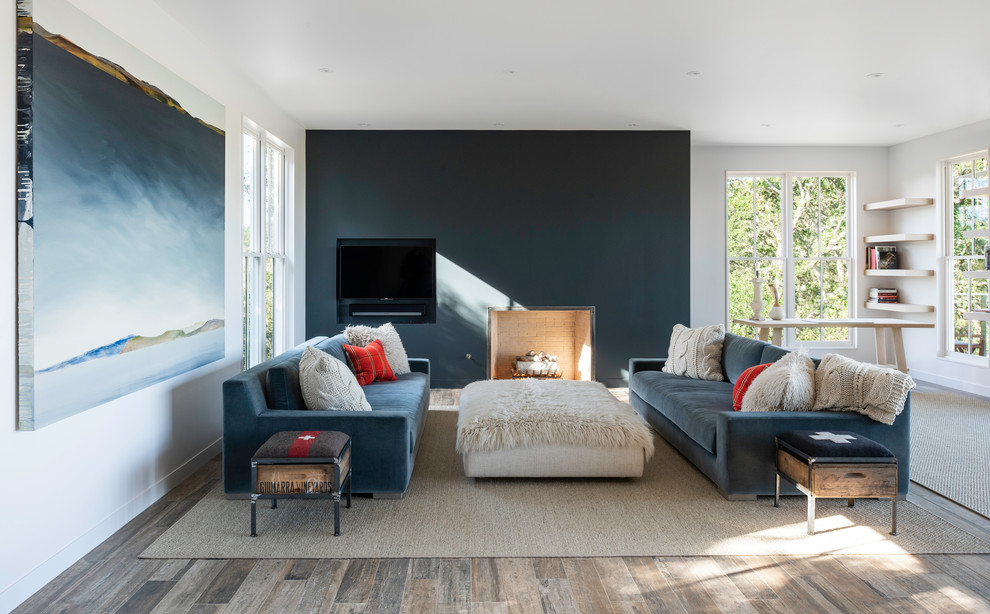 Example of a farmhouse medium tone wood floor family room design in San Francisco with white walls, no fireplace and a media wall