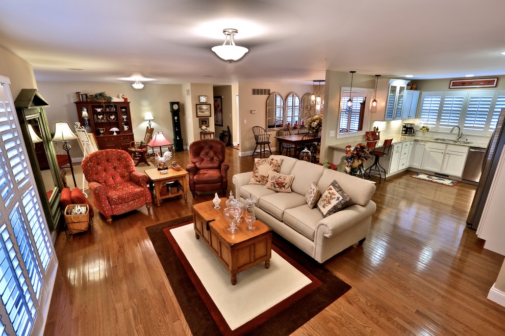 This is an example of a medium sized traditional open plan games room in Chicago with beige walls, medium hardwood flooring, a standard fireplace and a brick fireplace surround.