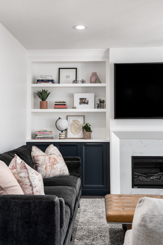 Foto de sala de estar tradicional renovada de tamaño medio con paredes blancas, suelo de madera oscura, todas las chimeneas, marco de chimenea de piedra, televisor colgado en la pared y suelo marrón