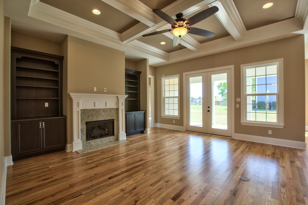 This is an example of a large classic games room in Atlanta with beige walls, dark hardwood flooring, a standard fireplace, a tiled fireplace surround and a wall mounted tv.