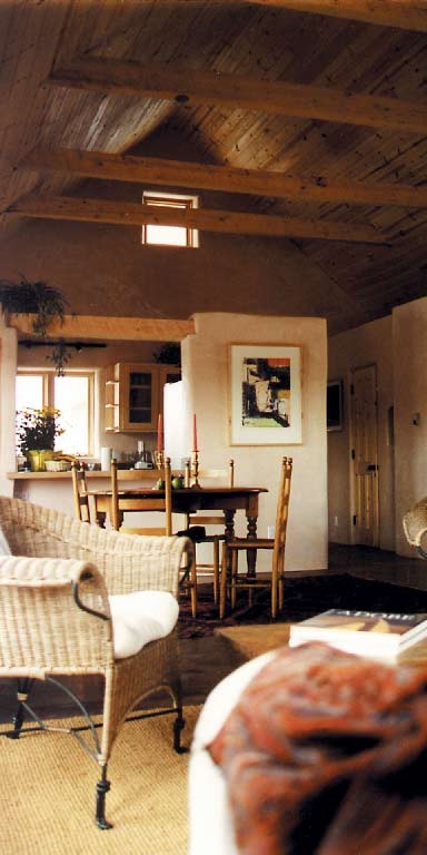 Cette photo montre une grande salle de séjour nature ouverte avec un mur multicolore, sol en béton ciré, aucune cheminée et un manteau de cheminée en plâtre.
