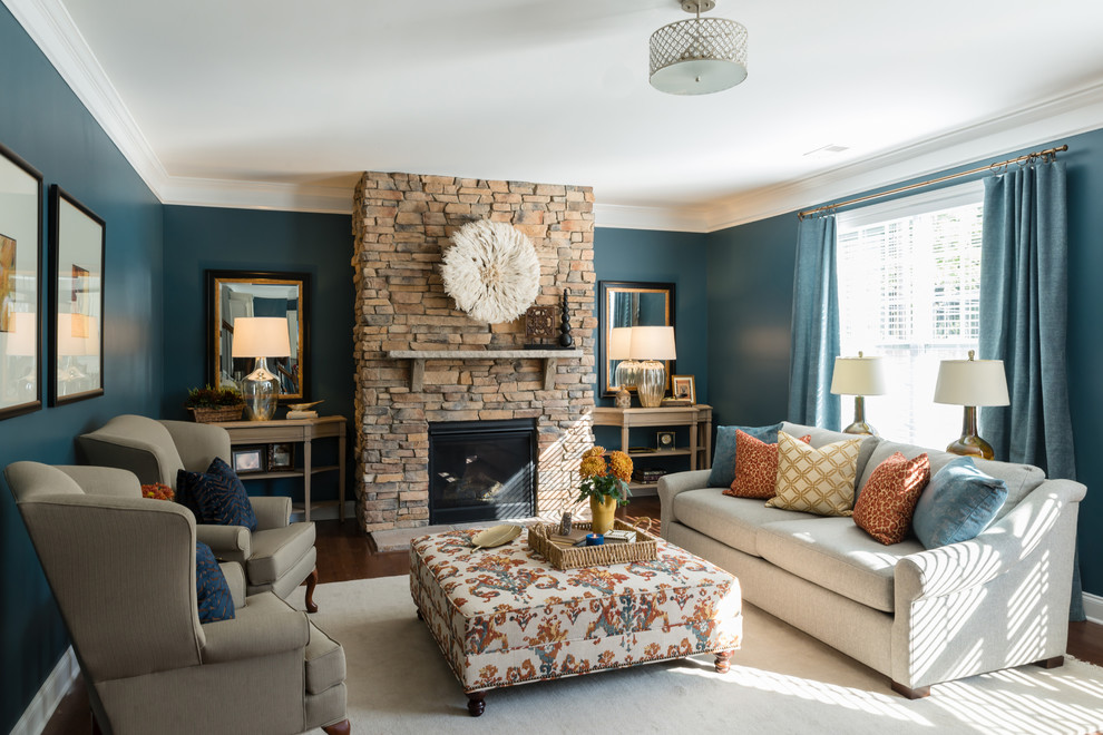 Ejemplo de sala de estar abierta tradicional renovada de tamaño medio sin televisor con paredes azules, suelo de madera en tonos medios, todas las chimeneas, marco de chimenea de piedra y suelo marrón