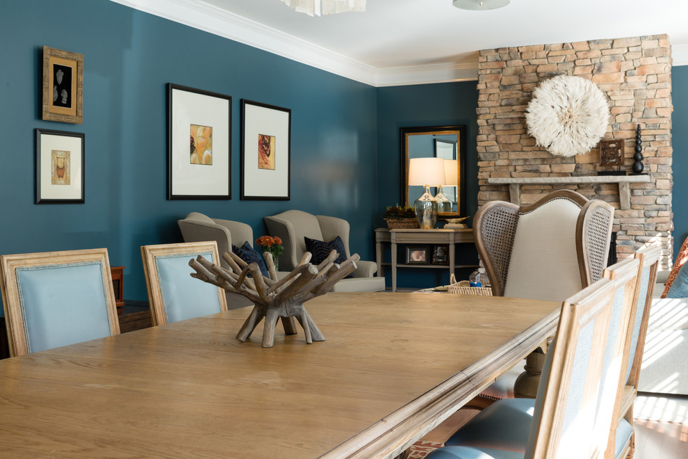 Imagen de sala de estar abierta tradicional renovada de tamaño medio sin televisor con paredes azules, suelo de madera en tonos medios, todas las chimeneas, marco de chimenea de piedra y suelo marrón
