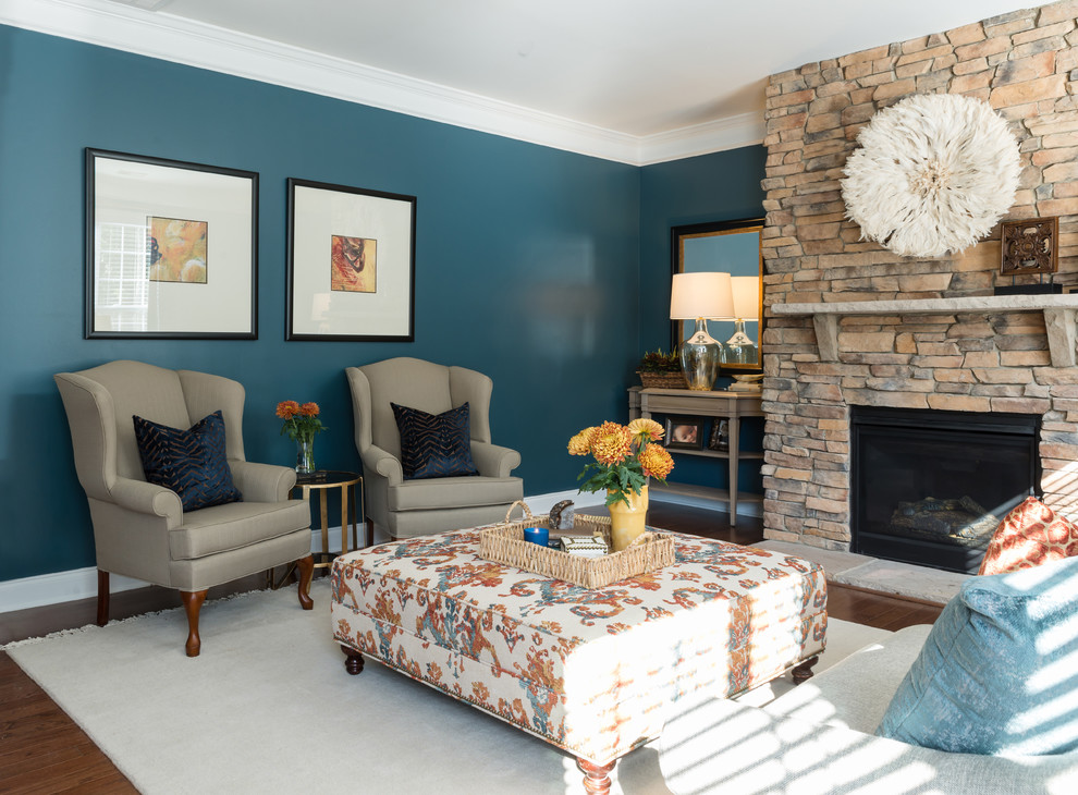 Источник вдохновения для домашнего уюта: открытая гостиная комната среднего размера в стиле неоклассика (современная классика) с синими стенами, паркетным полом среднего тона, стандартным камином, фасадом камина из камня и коричневым полом без телевизора