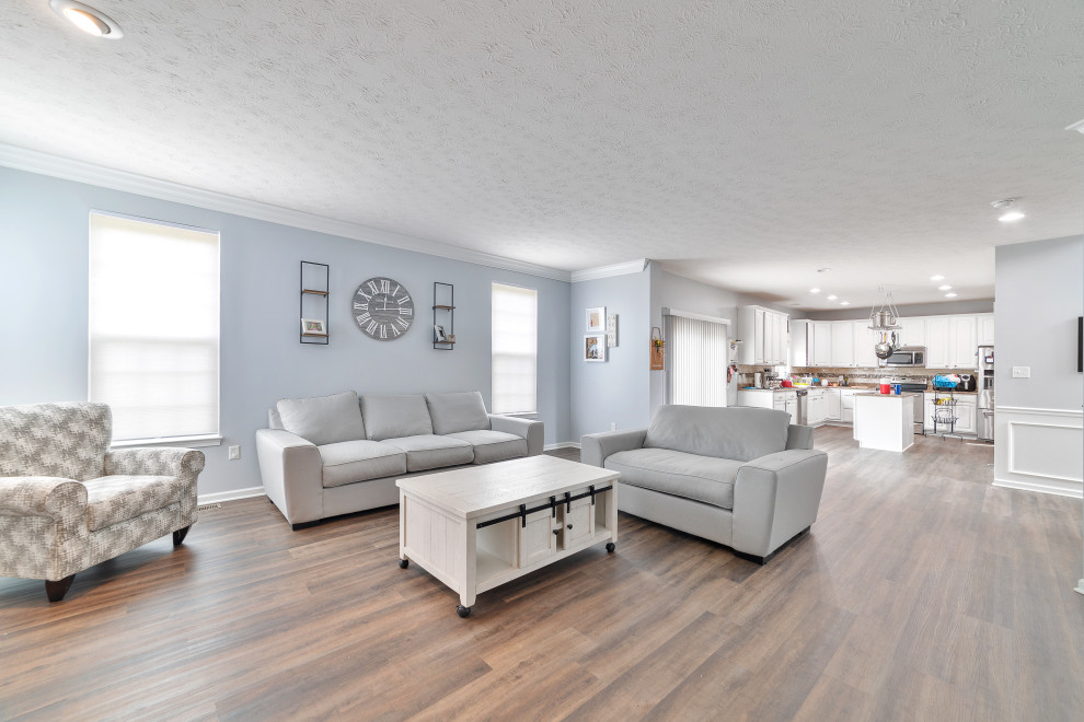 Imagen de sala de estar actual con paredes azules, suelo vinílico, todas las chimeneas, marco de chimenea de ladrillo y suelo marrón