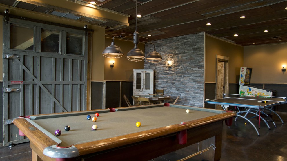 This is an example of an industrial games room in Atlanta with beige walls and concrete flooring.