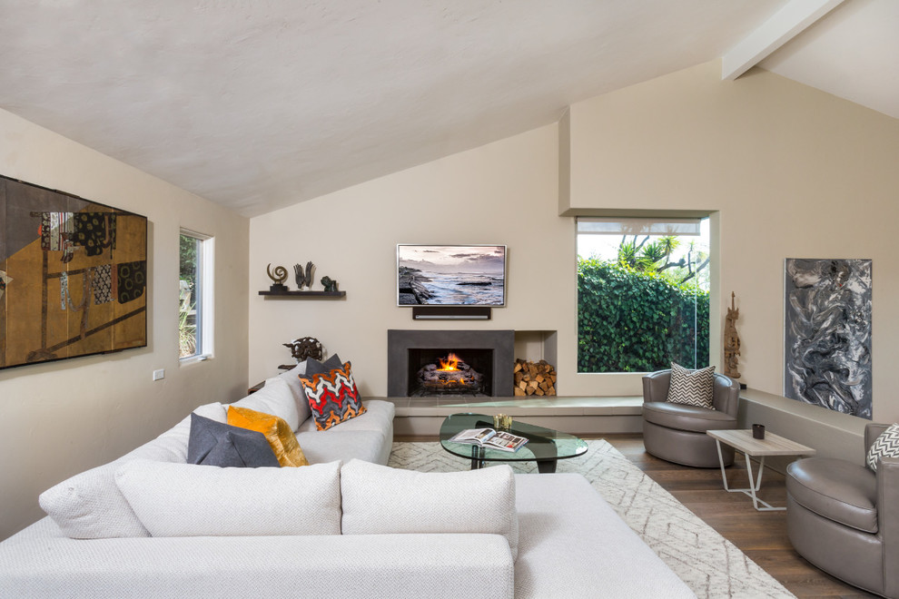 Foto di un grande soggiorno minimalista aperto con pareti beige, parquet scuro e stufa a legna