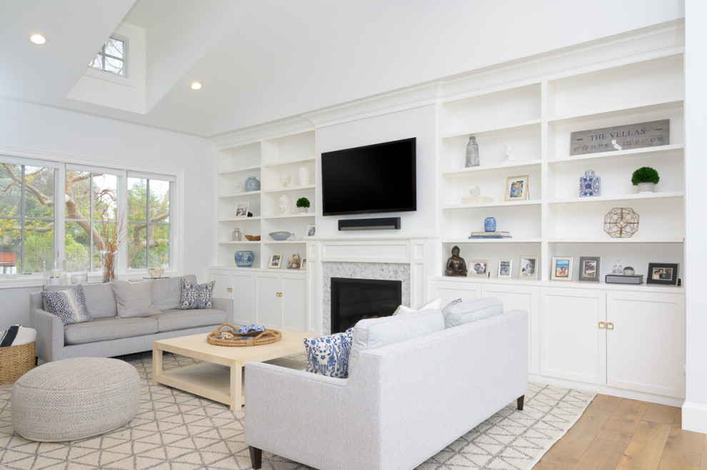 Klassisches Wohnzimmer mit weißer Wandfarbe, braunem Holzboden, Kamin, gefliester Kaminumrandung, TV-Wand, braunem Boden und gewölbter Decke in San Francisco