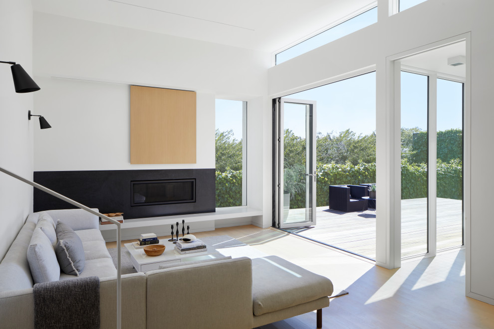 Ispirazione per un soggiorno moderno aperto con pareti bianche, parquet chiaro, camino classico e pavimento beige