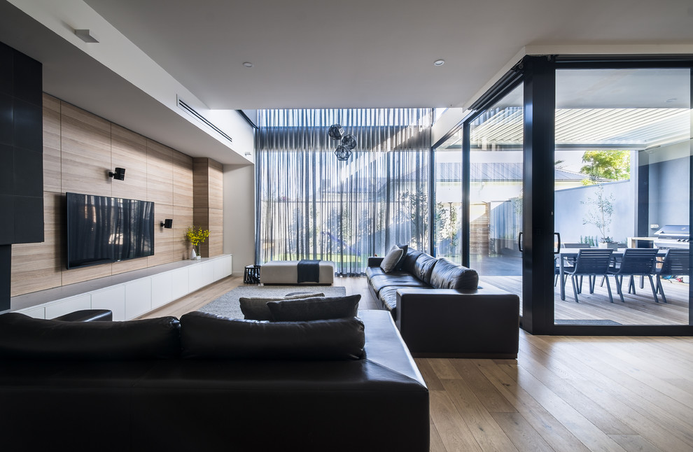 Стильный дизайн: открытая гостиная комната среднего размера в стиле модернизм с паркетным полом среднего тона, стандартным камином и фасадом камина из камня - последний тренд