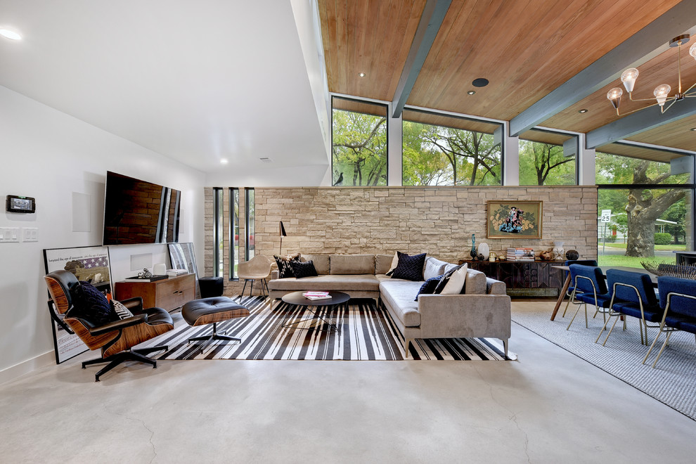 Example of a trendy open concept family room design in Austin with white walls and a wall-mounted tv