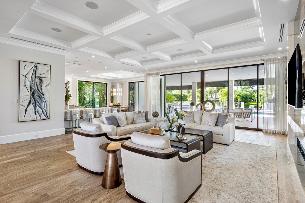 Offenes Modernes Wohnzimmer mit weißer Wandfarbe, braunem Holzboden, TV-Wand, braunem Boden und Kassettendecke in Miami