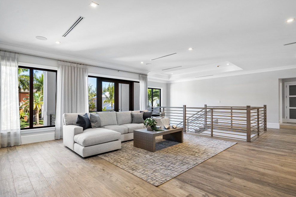 Réalisation d'une salle de séjour design ouverte avec un mur blanc, un sol en bois brun, un téléviseur fixé au mur, un sol marron et un plafond à caissons.
