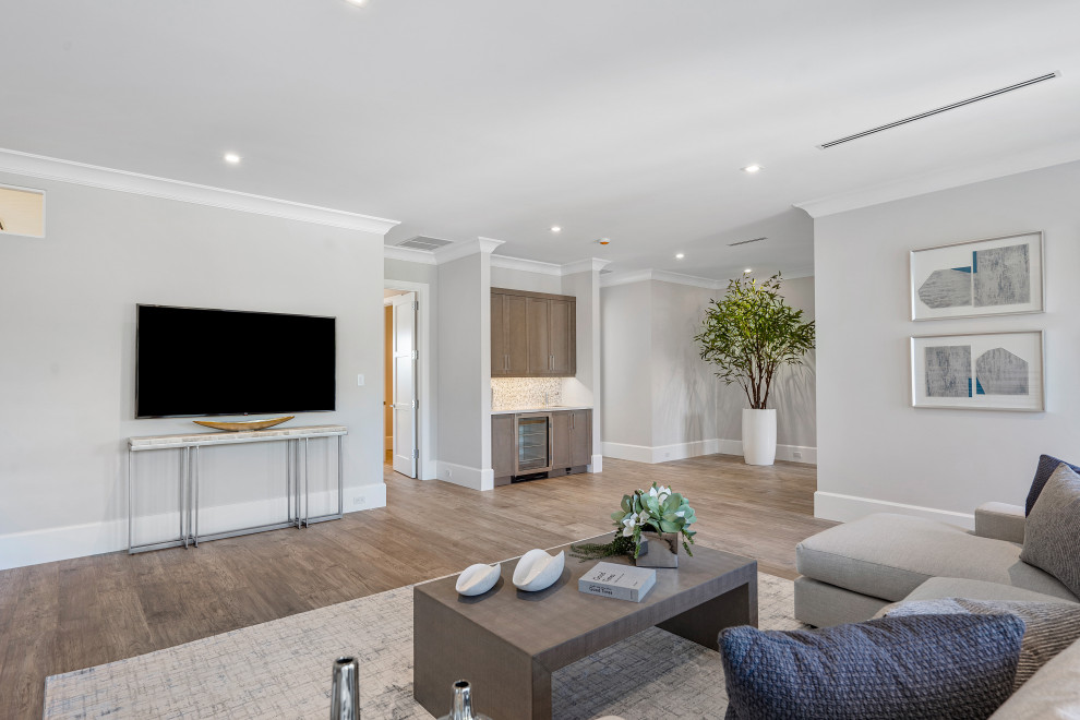 Ejemplo de sala de estar abierta actual con paredes blancas, suelo de madera en tonos medios, televisor colgado en la pared, suelo marrón y casetón