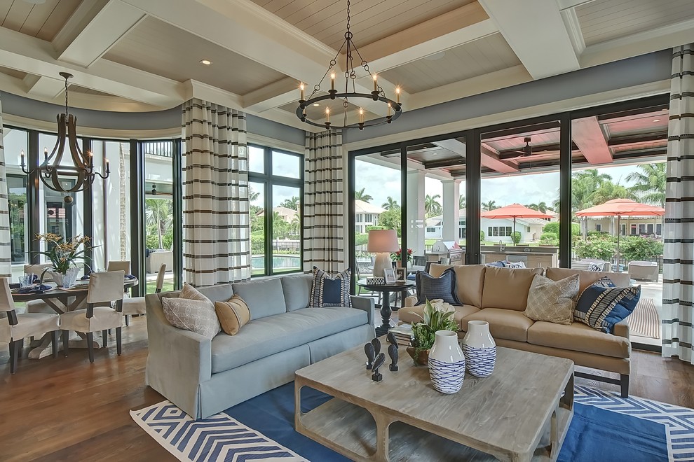 Imagen de sala de estar abierta tradicional renovada extra grande con paredes azules, suelo de madera en tonos medios y televisor colgado en la pared