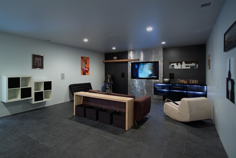 Источник вдохновения для домашнего уюта: большая изолированная комната для игр в современном стиле с серыми стенами, полом из сланца и телевизором на стене