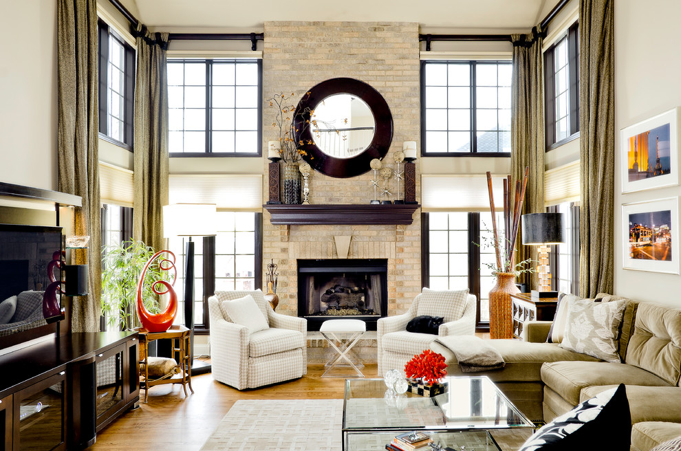 Photo of a medium sized contemporary open plan games room in Chicago with beige walls, light hardwood flooring, a brick fireplace surround and a standard fireplace.