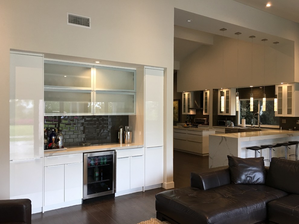 Mittelgroßes, Offenes Modernes Wohnzimmer mit beiger Wandfarbe, braunem Holzboden, Gaskamin, Kaminumrandung aus Metall, TV-Wand und braunem Boden in Orange County