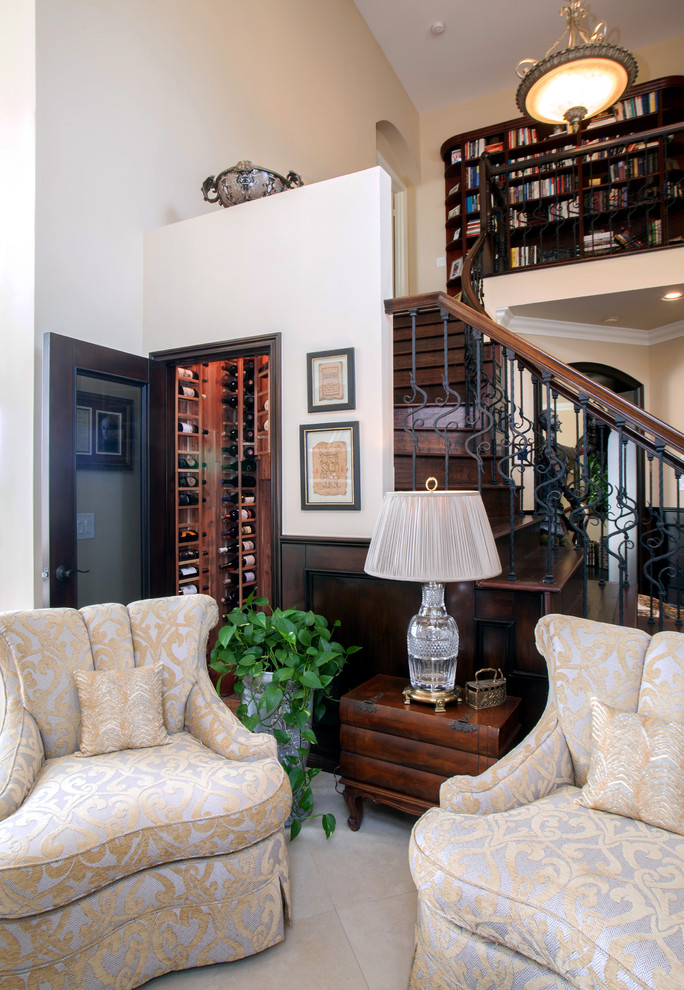 Modelo de sala de estar con biblioteca abierta clásica de tamaño medio sin chimenea y televisor con paredes beige, suelo de travertino y suelo beige