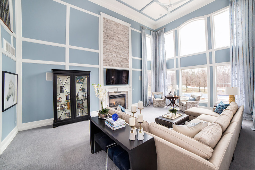 Large classic open plan games room in New York with a game room, blue walls, carpet, a standard fireplace, a stone fireplace surround, a wall mounted tv and grey floors.