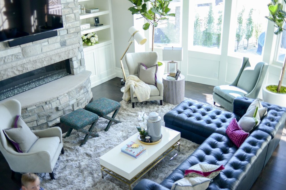 Ejemplo de sala de estar abierta minimalista grande con paredes grises, suelo de madera oscura, chimenea lineal, marco de chimenea de piedra y televisor colgado en la pared
