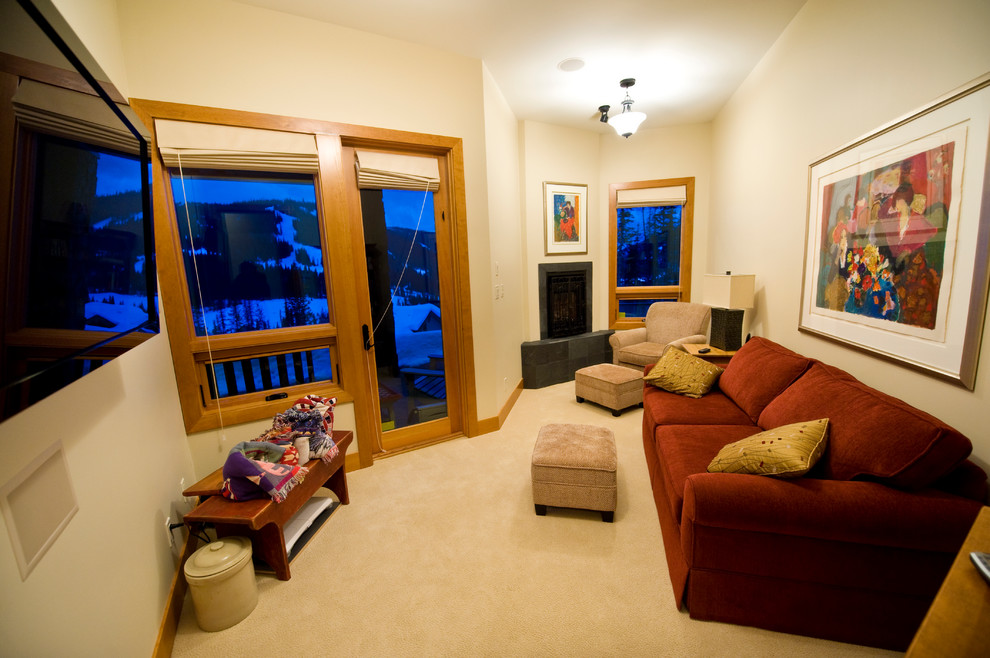 Diseño de sala de estar cerrada de estilo americano de tamaño medio con paredes beige, moqueta, chimenea de esquina, marco de chimenea de piedra y televisor colgado en la pared