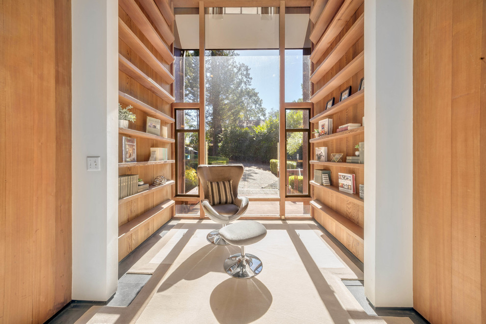 Esempio di un soggiorno minimal con libreria, pareti bianche e pavimento grigio
