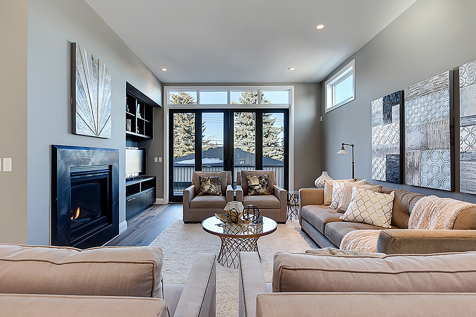 Idée de décoration pour une salle de séjour tradition ouverte avec un mur gris, un sol en bois brun et une cheminée standard.
