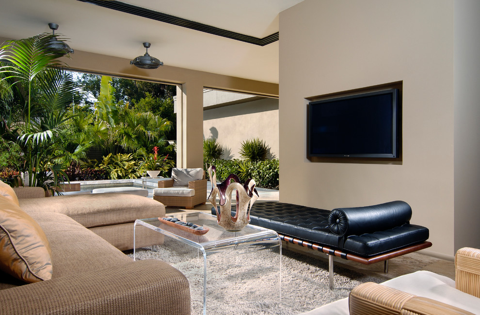 Immagine di un soggiorno contemporaneo aperto con pareti beige e TV a parete