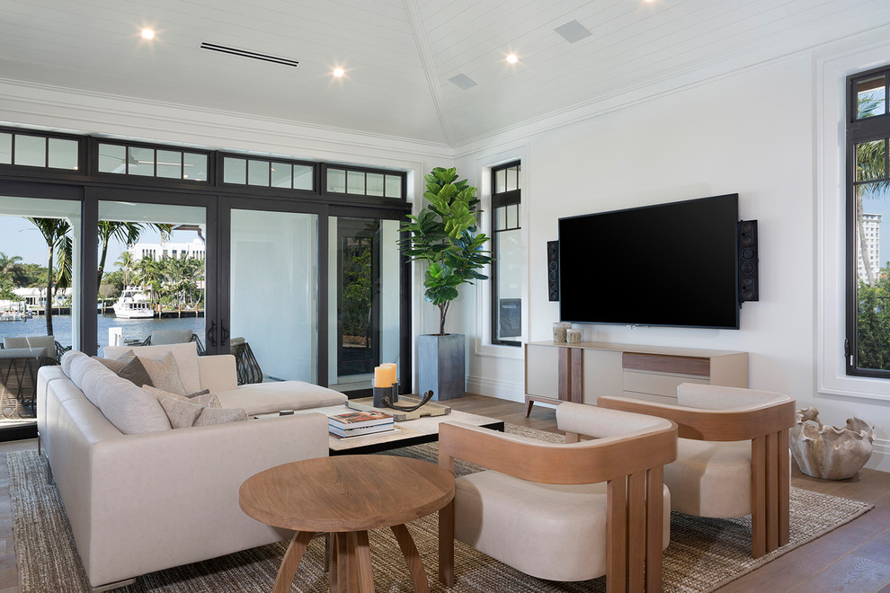 Large trendy enclosed dark wood floor and brown floor family room photo in Miami with white walls, no fireplace and a wall-mounted tv