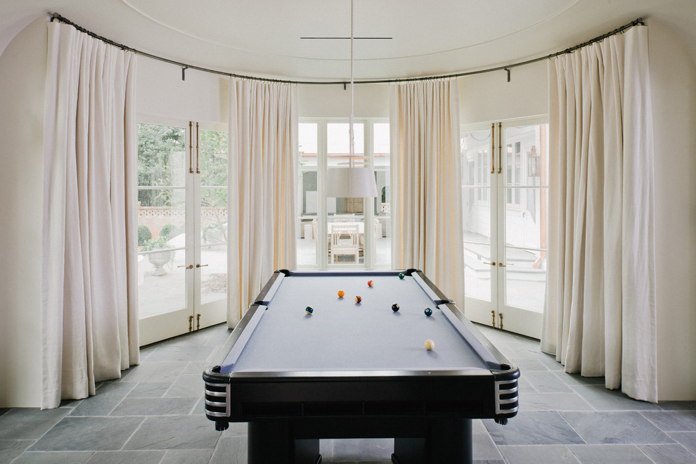 This is an example of an expansive classic enclosed games room in Charlotte with white walls and slate flooring.