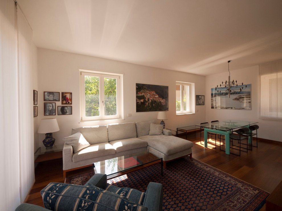 Foto di un soggiorno minimalista di medie dimensioni e aperto con libreria, pareti bianche, pavimento in legno massello medio, nessun camino e TV autoportante